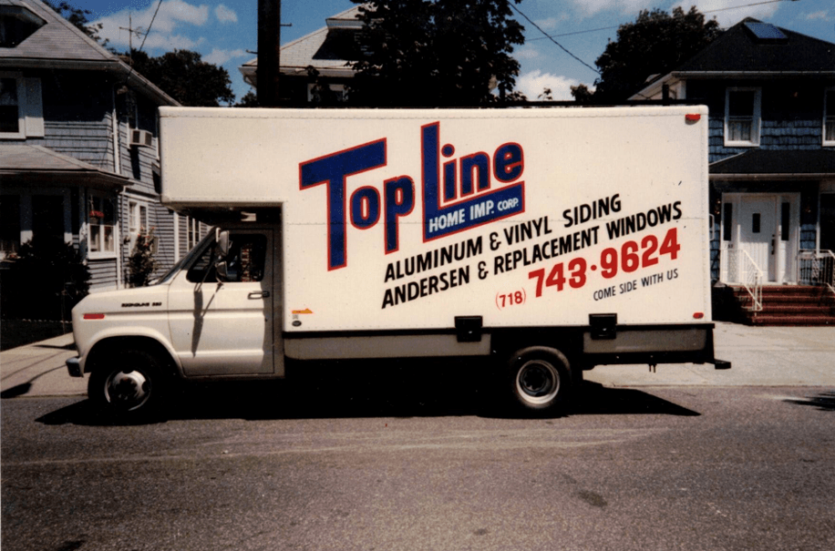 White Top Line Home Improvement box truck parked on a residential street.